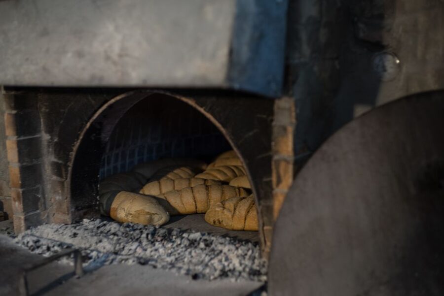 From Mykonos: Mykonian Farm Baking Class with Brunch - Kneading dough with Mike in the outdoor kitchen